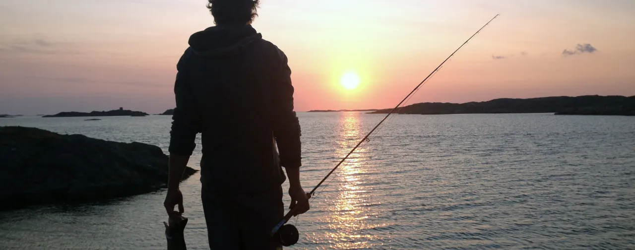 fiskare vid hav i solnedgång