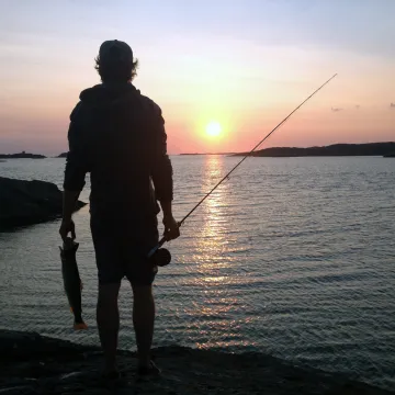 fiskare vid hav i solnedgång