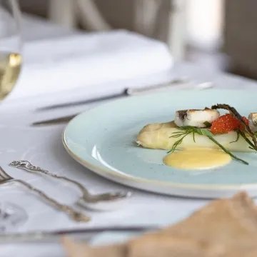 vit sparris på ljusblå tallrik, vinglas