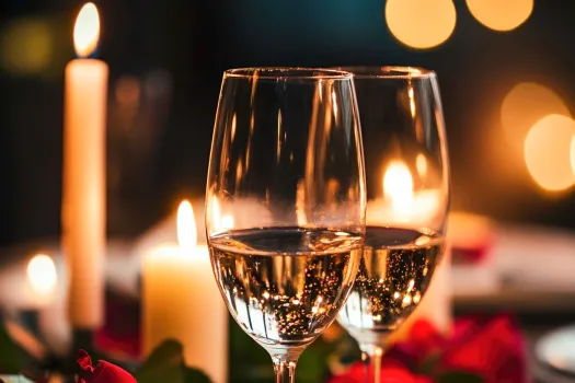 två glas mousserande vin, tända stearinljus