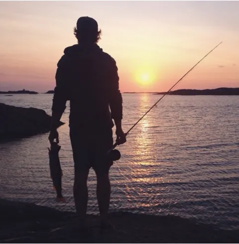 fiskare vid hav i solnedgång