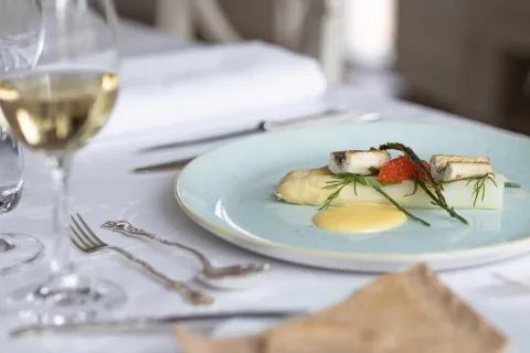 vit sparris på ljusblå tallrik, vinglas