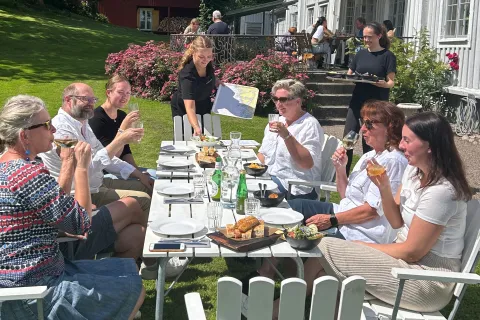 dukat bord i trädgård, människor runt bordet, sommarkänsla