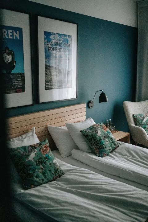 bäddad säng, hotellrum blå vägg