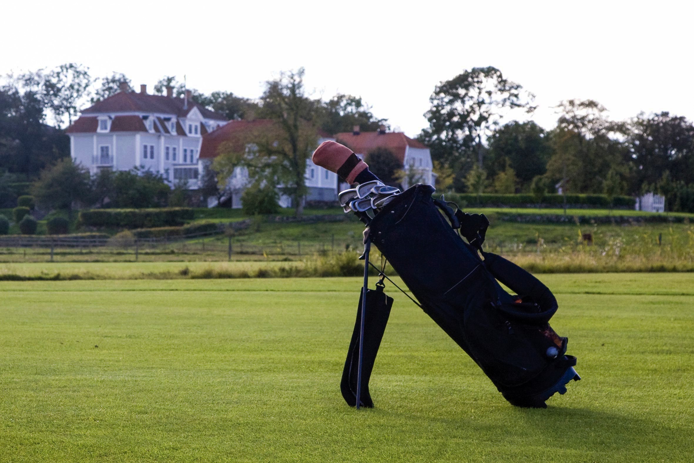 Golfbag på Lycke golfbana med Tofta Herrgårds huvudbyggnad i bakgrunden