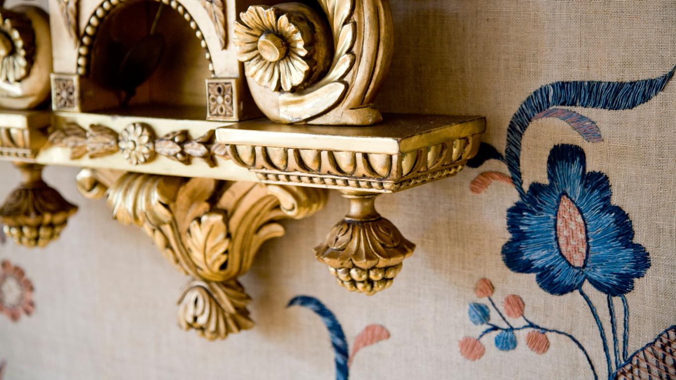 Detalj från matsal i restaurang tofta herrgård - guldigt väggur och detalj från tapet i Blekingesöm